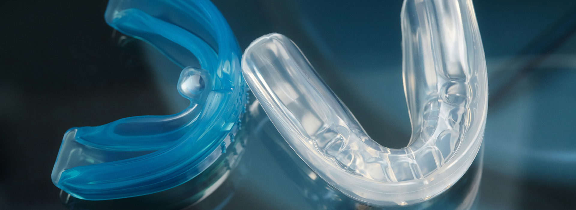 A close-up photograph of a clear plastic toothbrush with blue bristles.