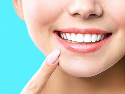 A close-up of a person s face smiling with teeth, focusing on the mouth and chin area.